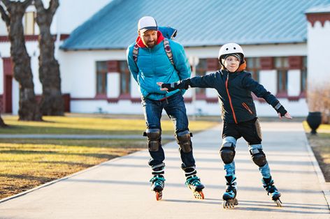 Vater und Sohn fahren Inline-Skater