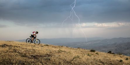Biker auf einem Mountainbike an einem stürmischen Tag mit Gewitter