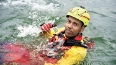 Rettungstaucher in gelbem Anzug und Helm im Wasser während einer Rettungsübung