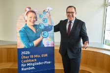 Jens Hasselbächer, Vorstand des Ressorts Kunden & Vertrieb der R+V Versicherung, mit einem Werbe-Aufsteller von Enie van de Meiklokjes