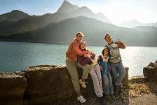 Eine Familie genießt ihren Urlaub in den Bergen, abgesichert durch eine Auslandsreisekrankenversicherung.