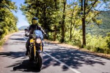 Motorradfahrer mit voller Schutzausrüstung genießt Fahrt auf Landstraße