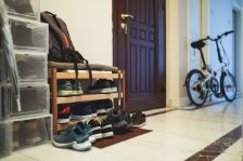 Ein Schuhregal, Fahrrad und Regal stehen im Flur.