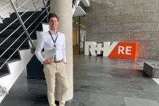Underwriter Fabia Lassen steh im Treppenhaus vor dem Logo der R+V Re