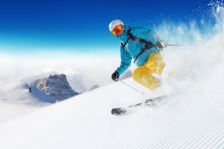 Mann fährt Ski auf Skipiste.
