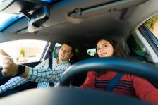 Vater, der seiner Tochter im Teenageralter das Autofahren beibringt und ihr hilft, Sicherheit im Straßenverkehr zu lernen