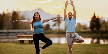 Ein Paar praktiziert Yoga im Freien.