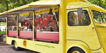 Manna Mobil - ein gelber Foodtruck mit ehrenamtlichen Helfern