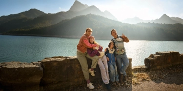 Eine Familie genießt ihren Urlaub in den Bergen, abgesichert durch eine Auslandsreisekrankenversicherung.