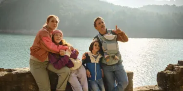 Eine Familie genießt ihren Urlaub in den Bergen, abgesichert durch eine Auslandsreisekrankenversicherung.