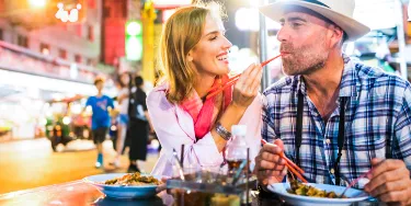 Ein Touristen-Paar genießt das Essen auf ihrer Thailand-Reise.