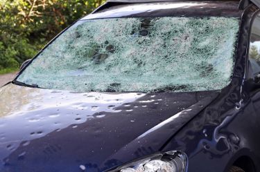 Hagelschaden an einem Auto. Große Hagelkörner haben ein Auto völlig zerstört