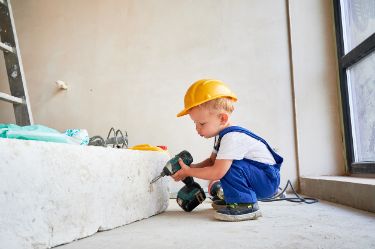 Ein kleiner junge ist am heimwerken.
