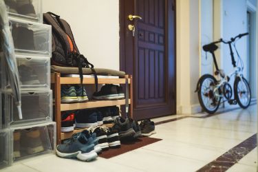 Ein Schuhregal, Fahrrad und Regal stehen im Flur.