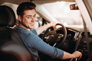 Ein Mann sitzt im Auto und fährt.