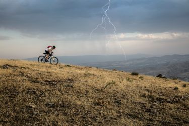 Biker auf einem Mountainbike an einem stürmischen Tag mit Gewitter