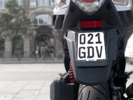 Rückseite eines Rollers mit einem schwarzen Versicherungskennzeichen.