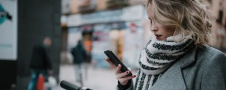 Junge Frau fährt mit dem E-Scooter durch die Stadt.