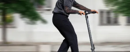 Junger Mann fährt auf seinem E-Scooter und beide sind gut versichert.