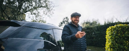 Ein Mann freut sich über die THG-Prämie für sein Elektroauto.
