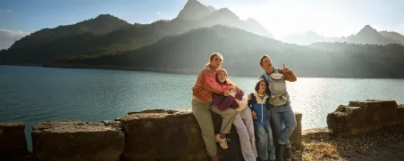 Eine Familie genießt ihren Urlaub in den Bergen, abgesichert durch eine Auslandsreisekrankenversicherung.