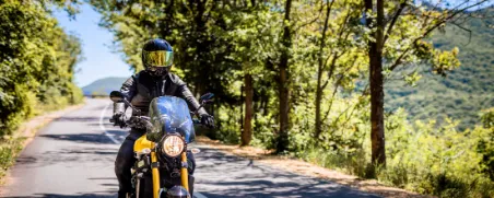 Motorradfahrer fährt unbeschwert auf seinem Leichtkraftrad dank der 125er-Versicherung.