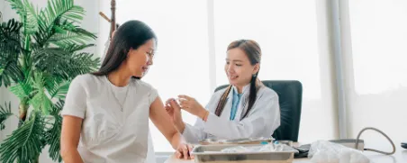 Eine Ärztin impft eine Frau gegen Gürtelrose.