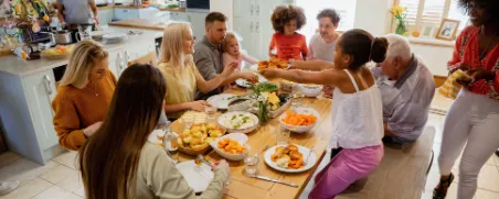Menschen einer Verantwortungsgemeinschaft sitzen am Tisch und essen gemeinsam.