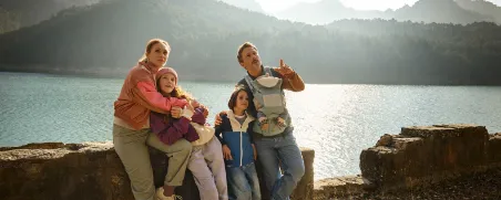 Eine Familie genießt ihren Urlaub in den Bergen, abgesichert durch eine Auslandsreisekrankenversicherung.