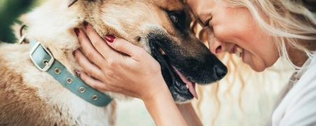 Eine Frau teilt einen glücklichen Moment mit ihrem Hund.