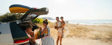 Eine Familie genießt den Urlaub mit dem Auto am Strand.