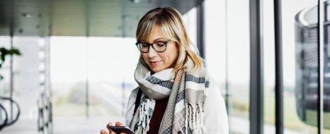 Frau mit Smartphone und Laptop
