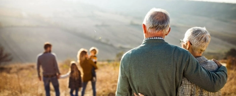  Ein älteres Paar, welches auf seine weggehende Familie/Jüngere Generation schaut.