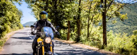 Motorradfahrer fährt unbeschwert auf seinem Leichtkraftrad dank der 125er-Versicherung.