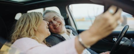 Glückliches Seniorenpaar unterwegs im Auto.