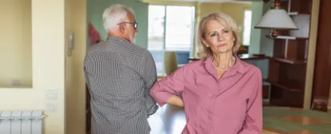 Ein aelterer Mann fuehrt eine ernsthafte Debatte mit seiner Frau