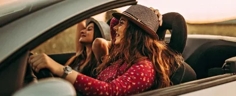 Zwei Frauen machen eine Spritztour im Cabrio.