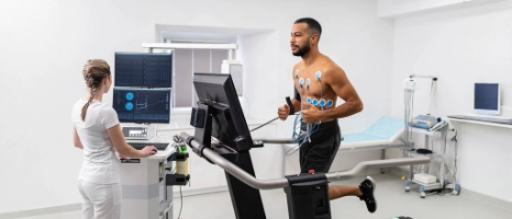 Ein Mann macht bei seiner Ärztin einen Belastungs-EKG im Rahmen der jährlichen Vorsorgeuntersuchung.
