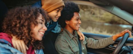 Mutter mit Kindern unterwegs im Auto.