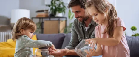 Eine Familie spart Geld in einer Spardose und nutzt im Alltag ihr Familienbudget. 