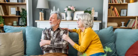 Ehemann wendet sich mit verschränkten Armen von seiner Frau ab.