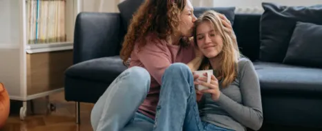 Eine Mutter umarmt ihre Tochter, die gerade in ihre erste eigene Wohnung gezogen ist.