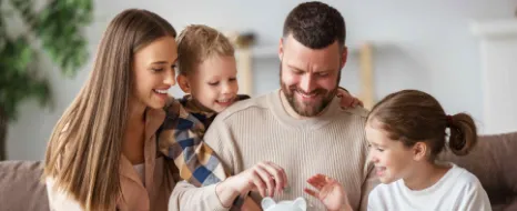 Familie mit Sparschwein als Symbol für Vermögensaufbau mit Kinder-Depot