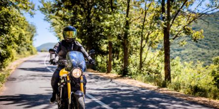 Motorradfahrer mit voller Schutzausrüstung genießt Fahrt auf Landstraße