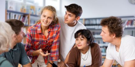 Junge Menschen sitzen an einem Tisch und diskutieren