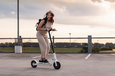 Frau fährt E-Scooter.