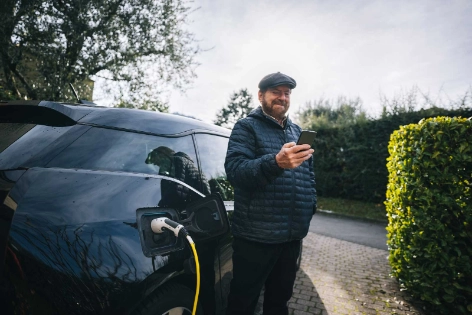 Ein Mann freut sich über die THG-Prämie für sein Elektroauto.