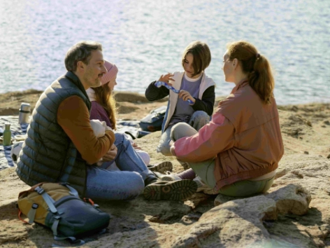 Eine Familie erklärt ihren Kindern die Vorteile einer Altersvorsorge.