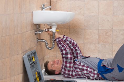 wasserschaden-klempner-repariert-waschbecken.jpg