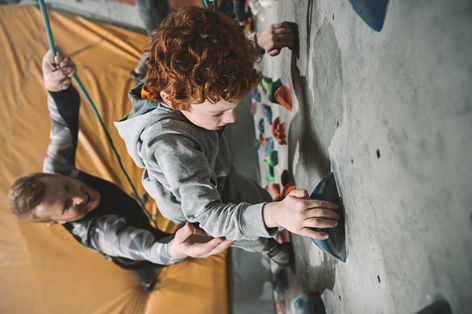 Kinder klettern an der Kletterwand